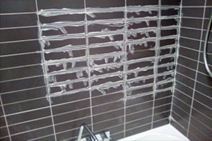 before image of regrouting around bath to reseal the wet area.